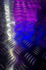 Reflection of colored display cases in a metal shiny floor.