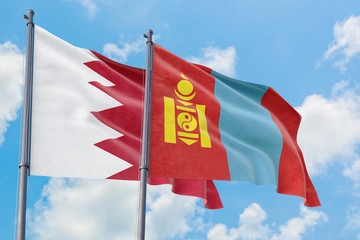 Mongolia and Bahrain flags waving in the wind against white cloudy blue sky together. Diplomacy concept, international relations.