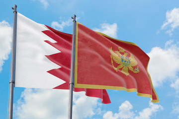 Montenegro and Bahrain flags waving in the wind against white cloudy blue sky together. Diplomacy concept, international relations.