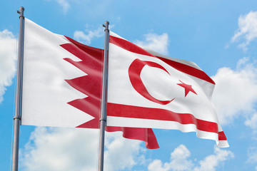 Northern Cyprus and Bahrain flags waving in the wind against white cloudy blue sky together. Diplomacy concept, international relations.