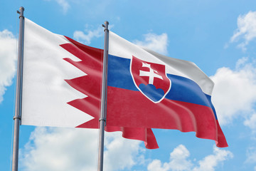 Slovakia and Bahrain flags waving in the wind against white cloudy blue sky together. Diplomacy concept, international relations.
