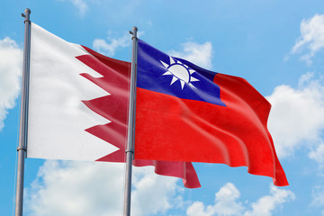 Taiwan and Bahrain flags waving in the wind against white cloudy blue sky together. Diplomacy concept, international relations.
