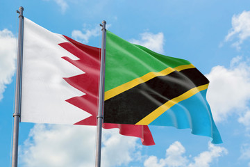 Tanzania and Bahrain flags waving in the wind against white cloudy blue sky together. Diplomacy concept, international relations.