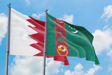 Turkmenistan and Bahrain flags waving in the wind against white cloudy blue sky together. Diplomacy concept, international relations.