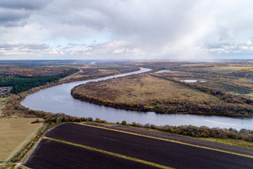 Bend of a large and wide river. Plowed fields along the riverbank.