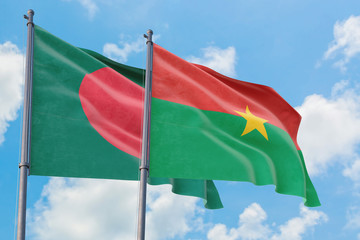 Burkina Faso and Bangladesh flags waving in the wind against white cloudy blue sky together. Diplomacy concept, international relations.