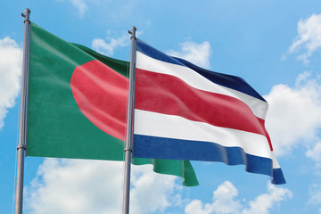 Costa Rica and Bangladesh flags waving in the wind against white cloudy blue sky together. Diplomacy concept, international relations.
