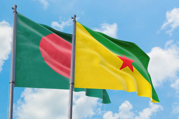 French Guiana and Bangladesh flags waving in the wind against white cloudy blue sky together. Diplomacy concept, international relations.