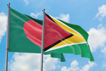Guyana and Bangladesh flags waving in the wind against white cloudy blue sky together. Diplomacy concept, international relations.