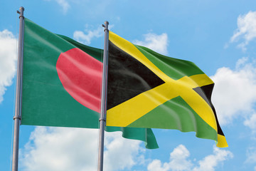 Jamaica and Bangladesh flags waving in the wind against white cloudy blue sky together. Diplomacy concept, international relations.