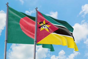Mozambique and Bangladesh flags waving in the wind against white cloudy blue sky together....