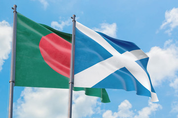 Scotland and Bangladesh flags waving in the wind against white cloudy blue sky together. Diplomacy concept, international relations.