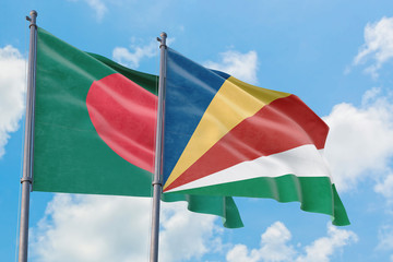 Seychelles and Bangladesh flags waving in the wind against white cloudy blue sky together. Diplomacy concept, international relations.