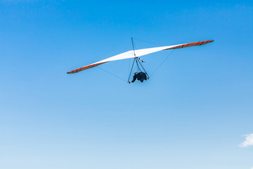Extremal air sports competition - Hang gliding. Overhead view of the soaring hang gliding pilot...