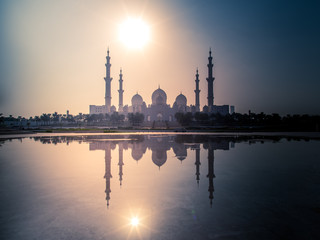 The Sheikh Zayed Grand Mosque with reflection on water and a beautiful sunset view