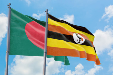 Uganda and Bangladesh flags waving in the wind against white cloudy blue sky together. Diplomacy concept, international relations.