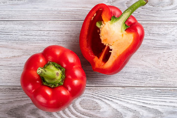 Red pepper cut in half close up on a wooden table