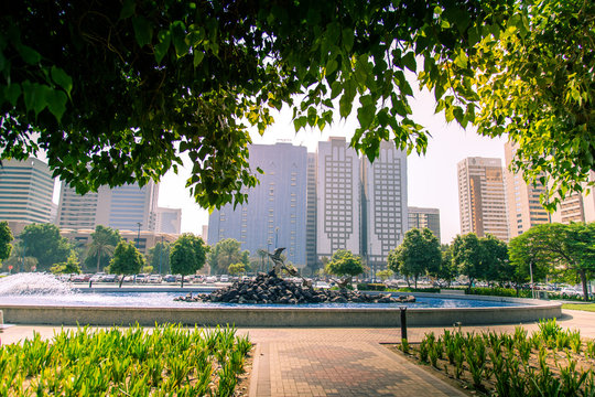 Lush green public garden or children's park at the Corniche with fountain at the Abu Dhabi City. - Powered by Adobe