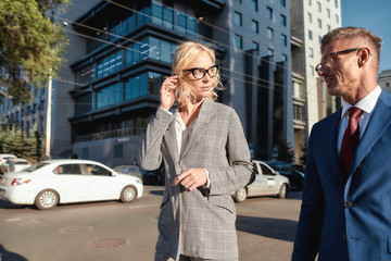 Successful partnership. Stylish man and woman in classic wear discussing new business strategy while standing outdoors