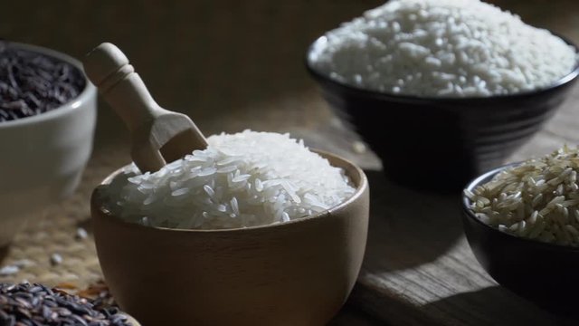 Organic brown rice and asian black riceberry with jasmine white rice in bowl on wooden desk, uncooked products by organic natural food concept