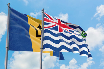 British Indian Ocean Territory and Barbados flags waving in the wind against white cloudy blue sky together. Diplomacy concept, international relations.