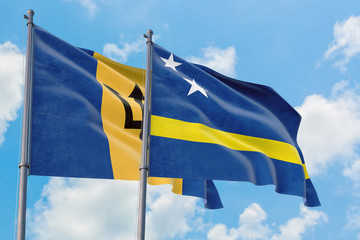 Curacao and Barbados flags waving in the wind against white cloudy blue sky together. Diplomacy concept, international relations.