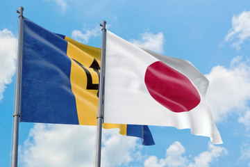Japan and Barbados flags waving in the wind against white cloudy blue sky together. Diplomacy...