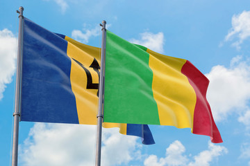Mali and Barbados flags waving in the wind against white cloudy blue sky together. Diplomacy concept, international relations.