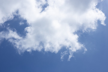 Blue sky background and white clouds passing by.