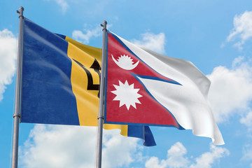 Nepal and Barbados flags waving in the wind against white cloudy blue sky together. Diplomacy concept, international relations.