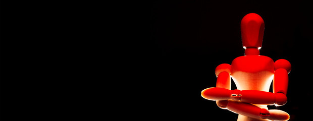 Wooden dummy in red tones and challenging attitude isolated from a black background