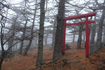 Fototapeta na wymiar A foggy journey to Mount Fuji, Japan. The Okumiya shrine at the summit of Mount Fuji is a detached shrine of Fujisan Hongū Sengen Taisha.