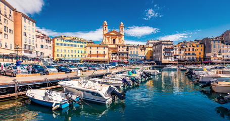Panoramic summer cityscape of Bastia port with twin-towered Church of St. Jean-Baptiste rising...