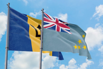 Tuvalu and Barbados flags waving in the wind against white cloudy blue sky together. Diplomacy concept, international relations.