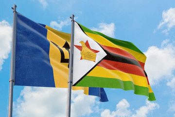 Zimbabwe and Barbados flags waving in the wind against white cloudy blue sky together. Diplomacy concept, international relations.