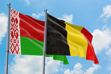 Belgium and Belarus flags waving in the wind against white cloudy blue sky together. Diplomacy concept, international relations.