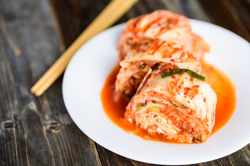 Kimchi cabbage on white plate with chopsticks, Korean food