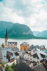 Fototapeta premium hallstatt church with bell tower lake with alpine mountains on background