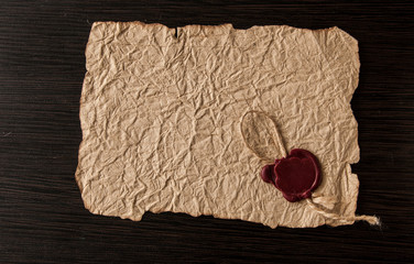 old paper with seal wax on black wooden background