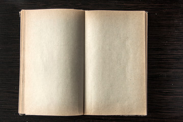 Vintage book, open, on old wooden table.