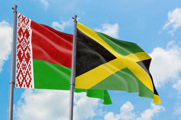 Jamaica and Belarus flags waving in the wind against white cloudy blue sky together. Diplomacy concept, international relations.