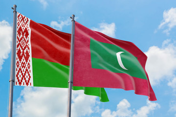 Maldives and Belarus flags waving in the wind against white cloudy blue sky together. Diplomacy concept, international relations.