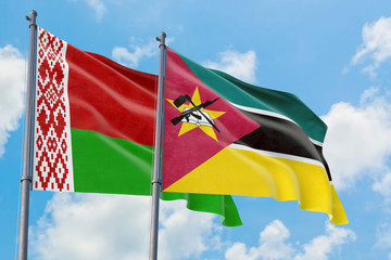 Mozambique and Belarus flags waving in the wind against white cloudy blue sky together. Diplomacy concept, international relations.