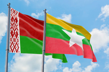 Myanmar and Belarus flags waving in the wind against white cloudy blue sky together. Diplomacy concept, international relations.
