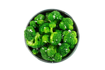 A bowl of cooked broccoli, isolated on a white background with a clipping path, shot from above...