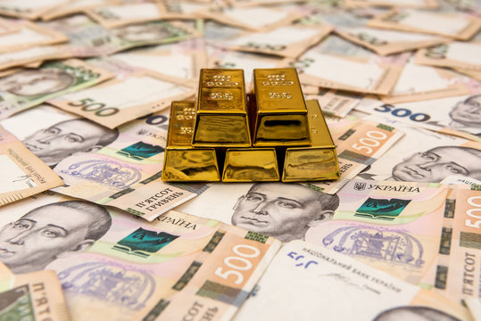 stacks of gold bars on ukraine moneu uah . top view
