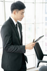 Portrait of a young businessman using a digital tablet in a modern office