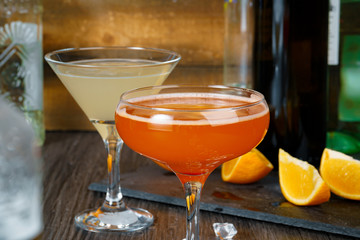 Two beautiful cocktails served on a wooden bar counter