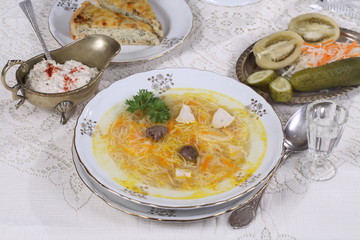 chicken soup with vermicelli, a glass of vodka and pickles