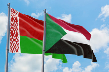 Sudan and Belarus flags waving in the wind against white cloudy blue sky together. Diplomacy concept, international relations.